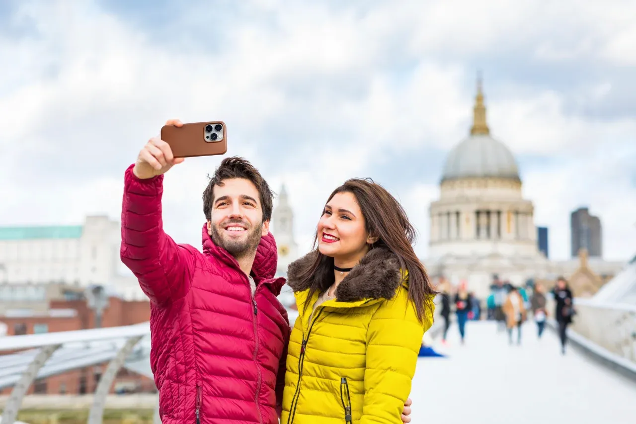 A couple taking a photo with St. Paul's Cathedral in the background