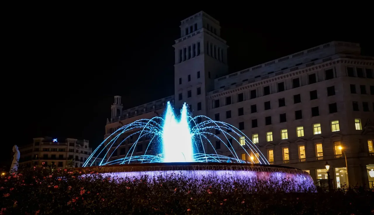 The fountain in Plaça de Catalunya lit up at night